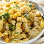 A plate with Cheesy Chicken Noodle Casserole in a creamy mushroom sauce with broccoli and chicken.