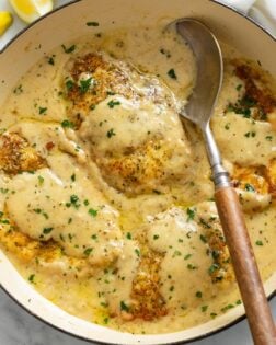 A skillet filled with Chicken in White Wine Sauce with parsley.