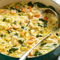 A soup pot with Lemon Chicken Orzo Soup with a ladle in it.