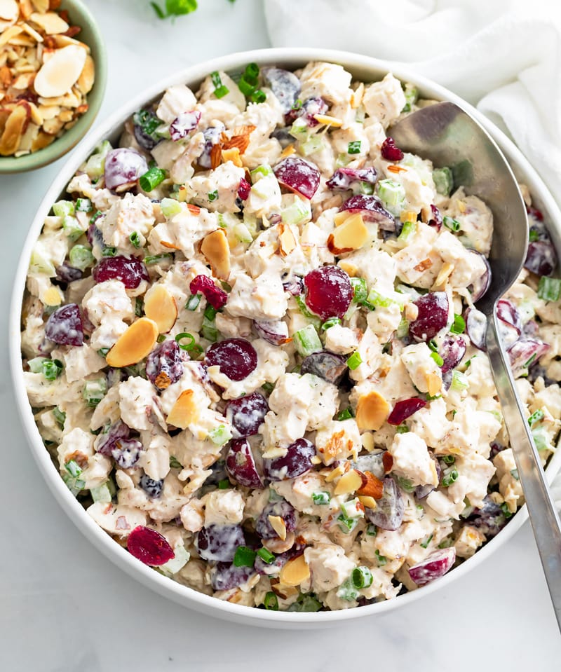 A big bowl of Chicken Salad with grapes, cranberries, sliced almonds, and more.