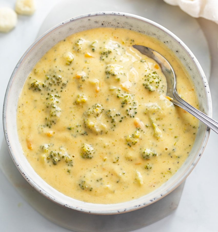 A bowl of Broccoli Cheese Soup with a spoon in it.