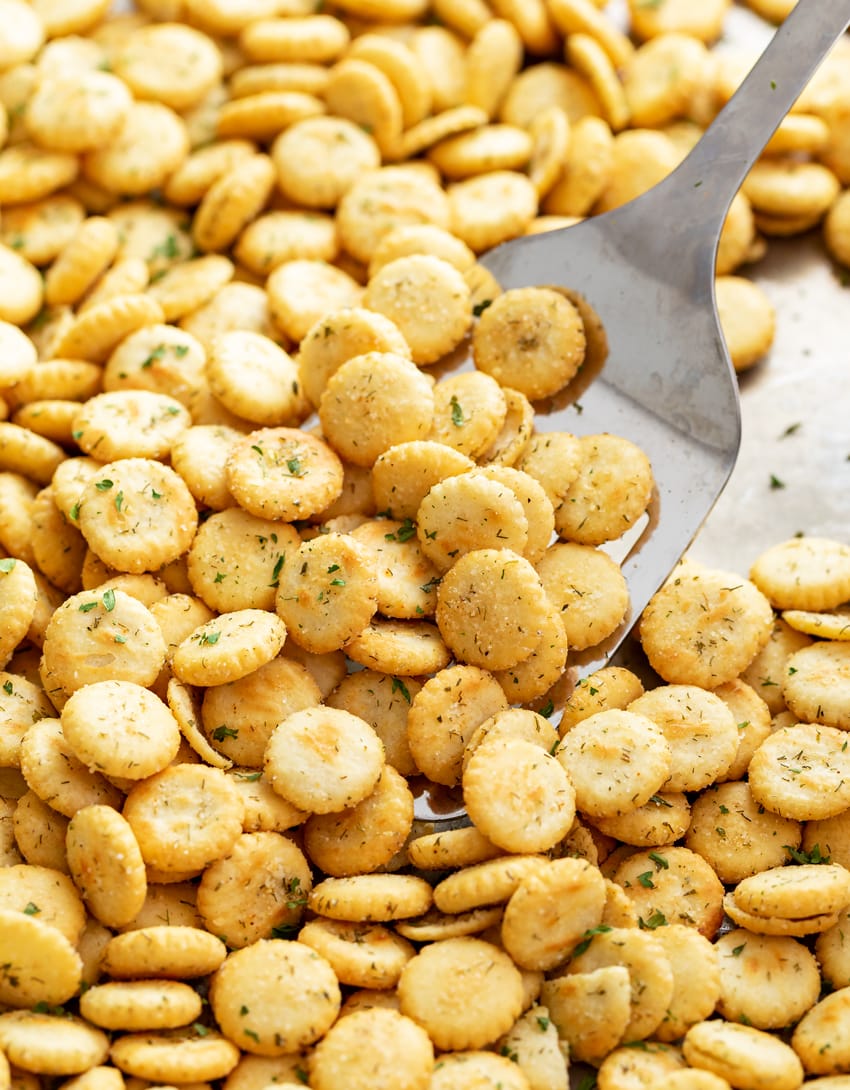 Ranch Oyster Crackers on a baking sheet with a spatula scooping them up.