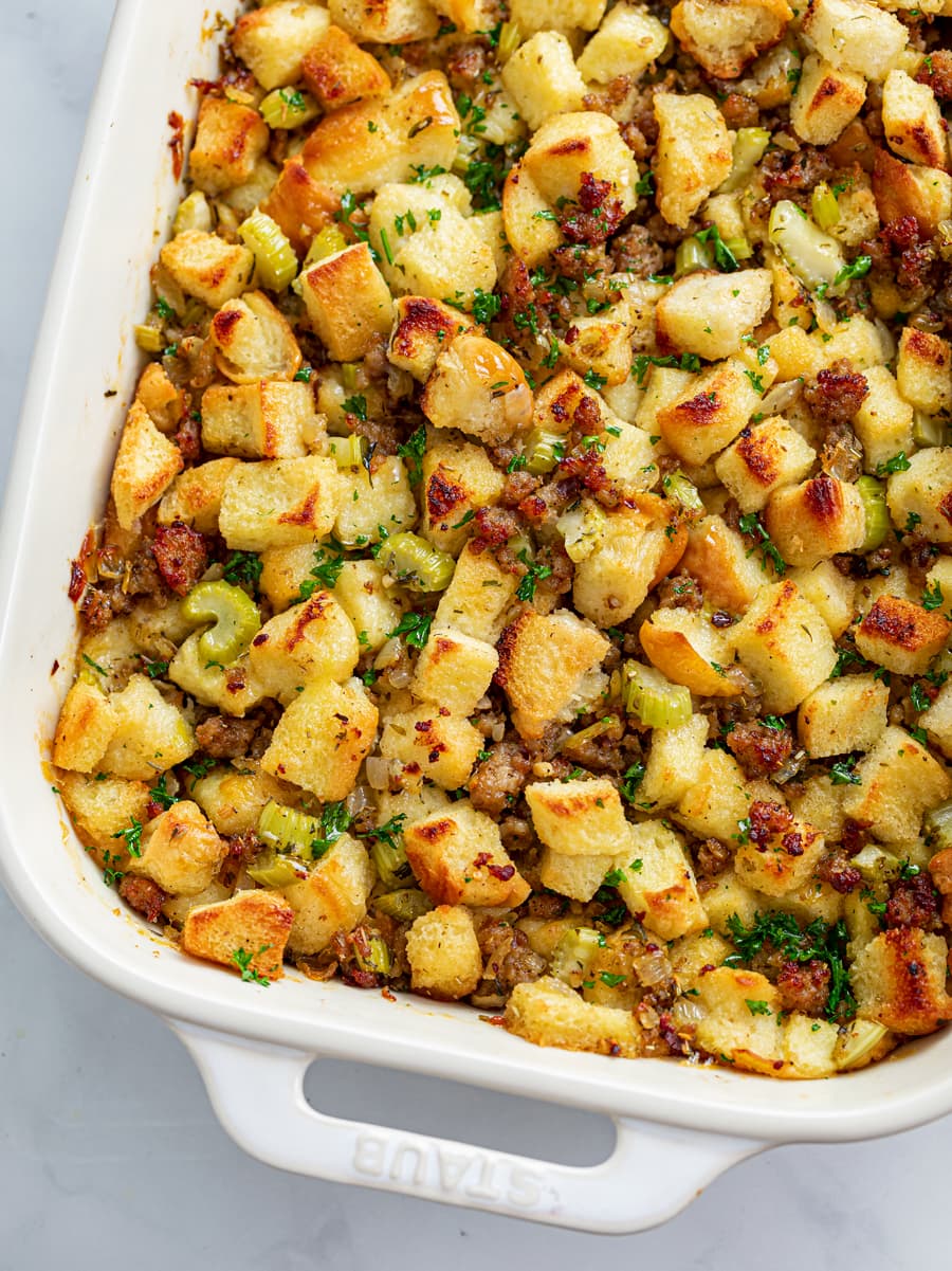 A white casserole dish filled with Sausage Stuffing.