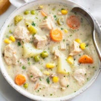 Creamy Chicken Soup in a white soup bowl with a spoon on the right side.