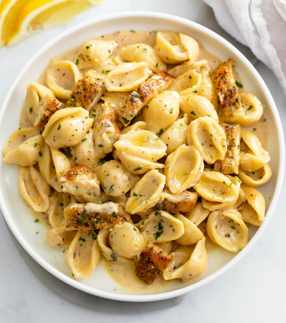 Creamy Chicken Pasta on a white plate with parsley on top.