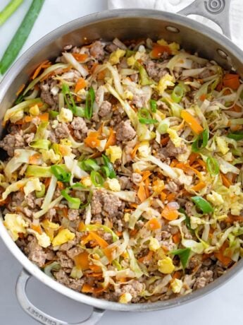 A skillet filled with Egg Roll in a Bowl with cabbage, carrots, pork, and scrambled eggs.