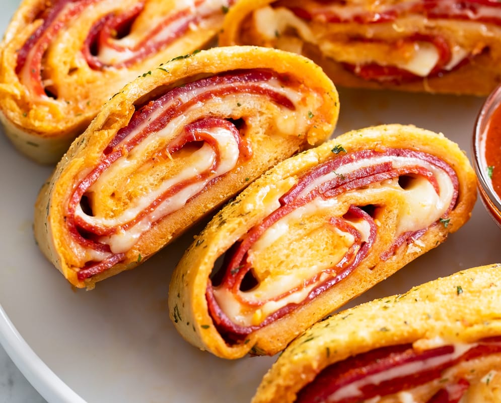 Stromboli slices stacked next to each other on a white plate.
