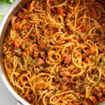 Taco Spaghetti in a skillet with taco meat and tomatoes.
