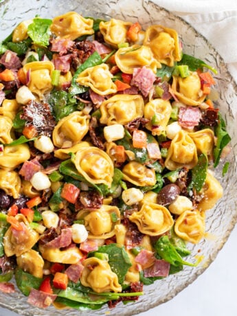 Tortellini Pasta Salad in meat, vegetables, and cheese in a glass bowl.