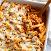 Ground Beef Casserole in a baking dish with a wooden spoon scooping it up.