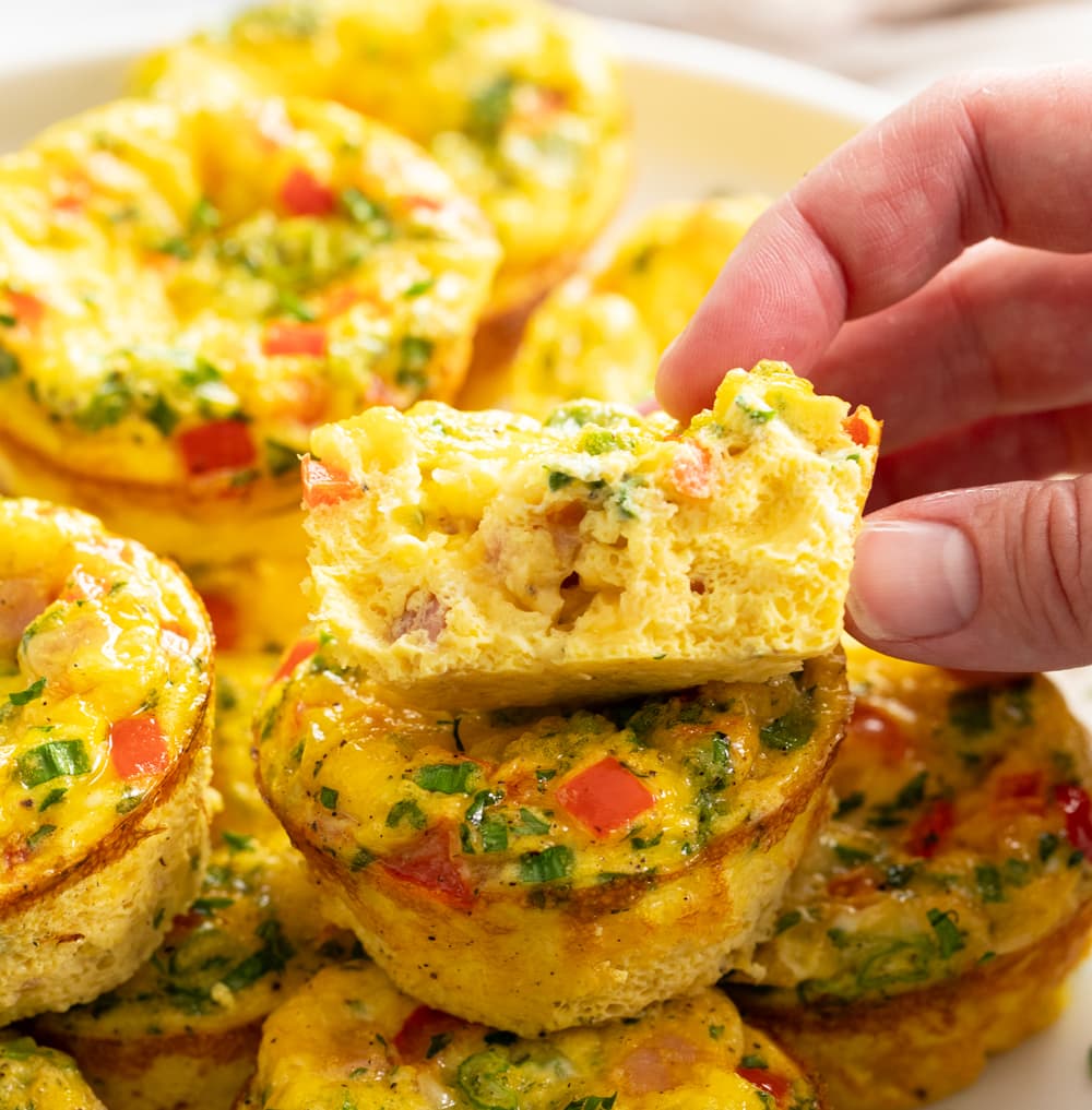 A fluffy egg muffin broken in half with a fluffy inside.
