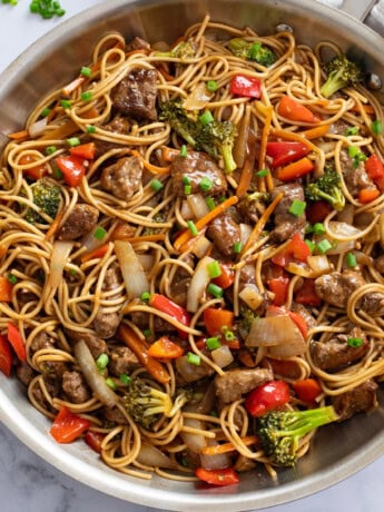 Beef Lo Mein in a skillet with beef, noodles, and vegetables in sauce.