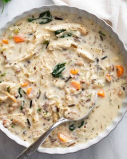 Chicken and Wild Rice Soup in a white serving bowl with a spoon on the side.