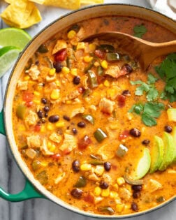 A bowl of Chicken Poblano Soup with sliced avocado on the side.