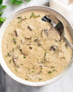 A bowl of Cream of Mushroom Soup with a spoon on the side.