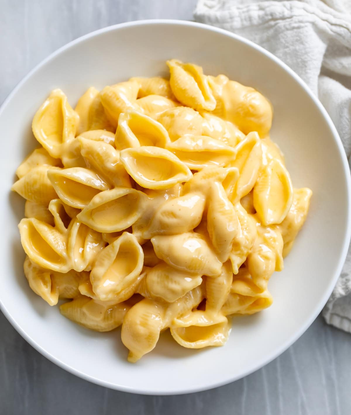 Creamy Shells and Cheese in a white bowl.
